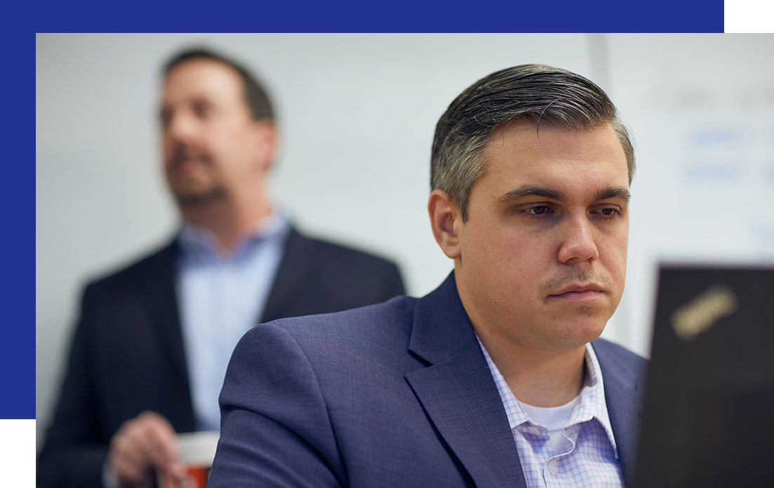 Access-Sciences-What-We-Do-Information-Management-Governance-FAQ A suited man focuses on a laptop, representing Information Management governance.