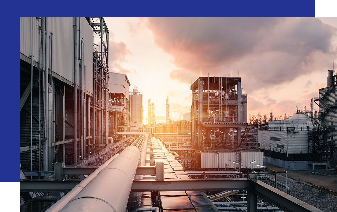 Access-Sciences-Case-Study-Evaluating-Business-Risk-to-Meet-Compliance-Deadline An industrial complex with pipelines and towers at sunset.