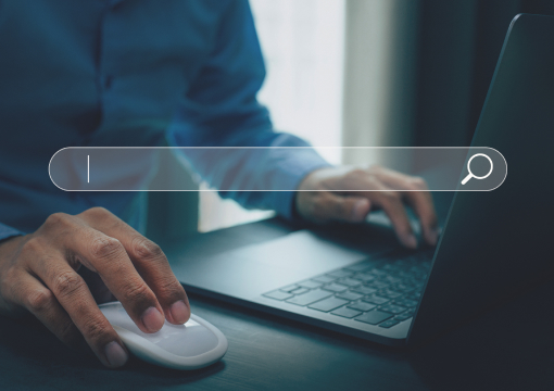 A person uses a laptop and a computer mouse with a virtual search bar overlayed on the image, symbolizing internet browsing or online searching.